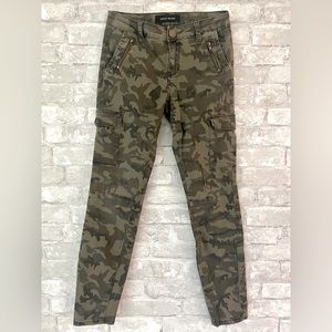 Skinny fit, low rise camouflage pants with diagonal zipper pockets in front.